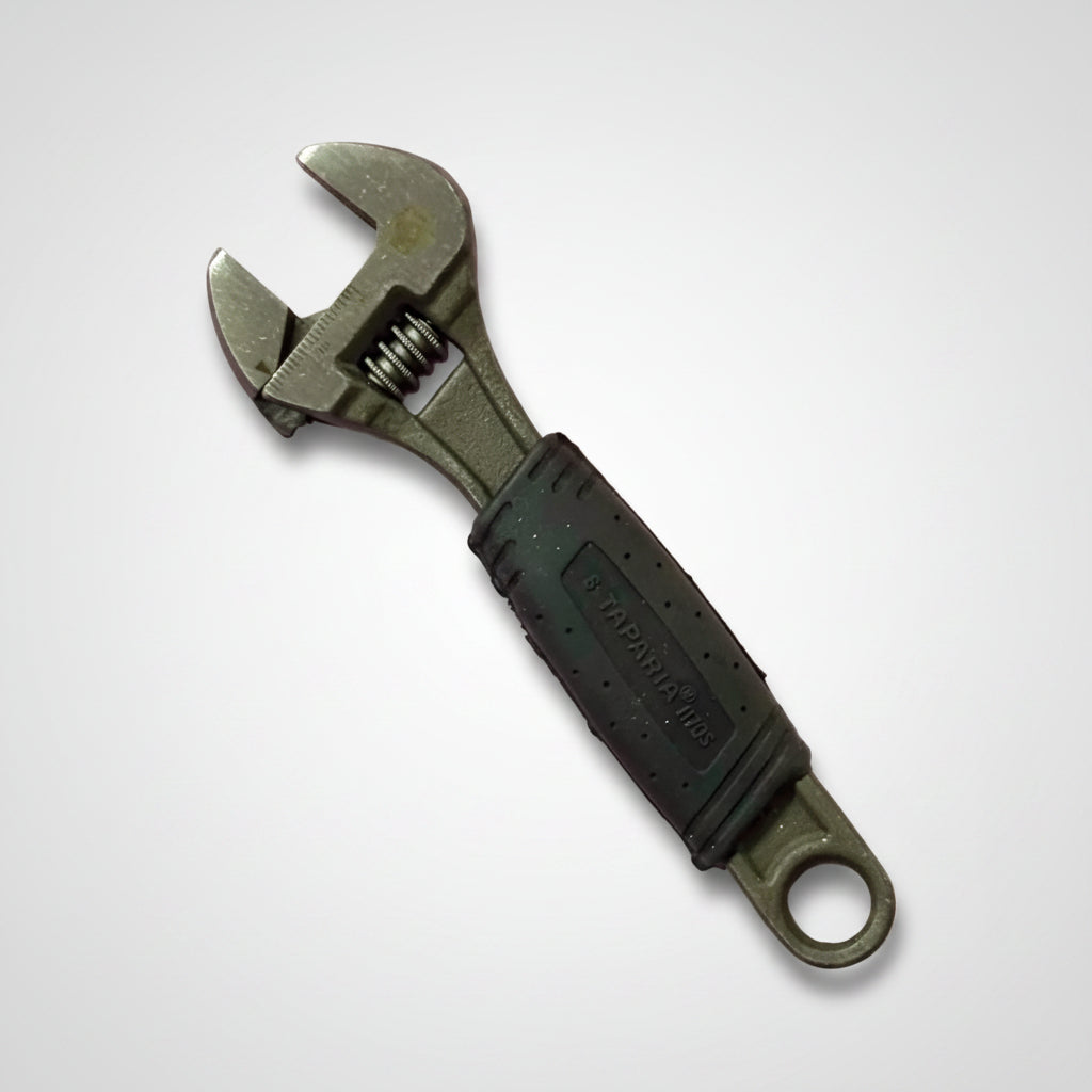 Taparia Adjustable Spanner 1170S-6 inch with ergonomic black rubber grip handle and precision adjustable jaw, placed on a pink background. Ideal for tightening and loosening nuts and bolts in plumbing, automotive, electrical, and maintenance applications.